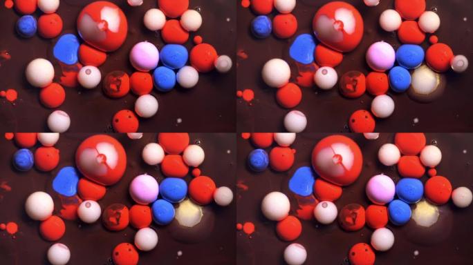 多色丙烯酸涂料气泡散布在宇宙色彩表面混合抽象设计中。金色闪闪发光的颗粒，墨球滴和混合。运动中的彩色油