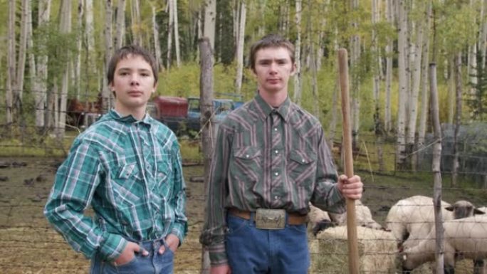 在美国科罗拉多州的一个小镇家族牧场上，两个年轻的牧场主男孩站在一起看着相机的视频肖像