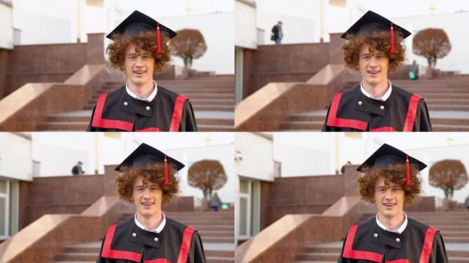 快乐的小男孩大学毕业于传统的黑色bonet和masters mantle手握文凭，看着大学建筑背景上