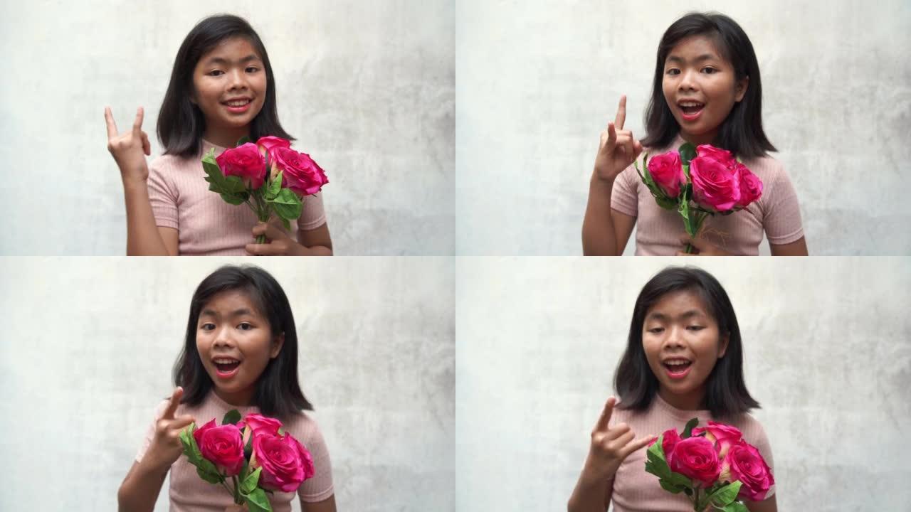 亚洲少女手持一束粉红玫瑰，摆姿势沙卡标志，决心决定成功，白色旧墙背景