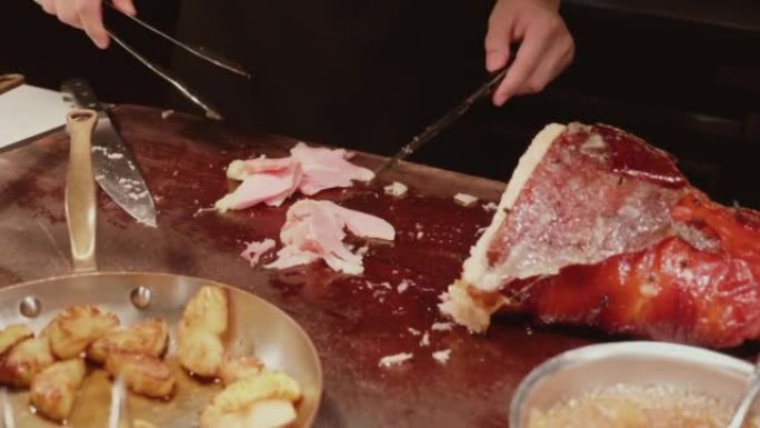 厨师在豪华餐厅用烟熏腿切成薄片烤猪肉火腿