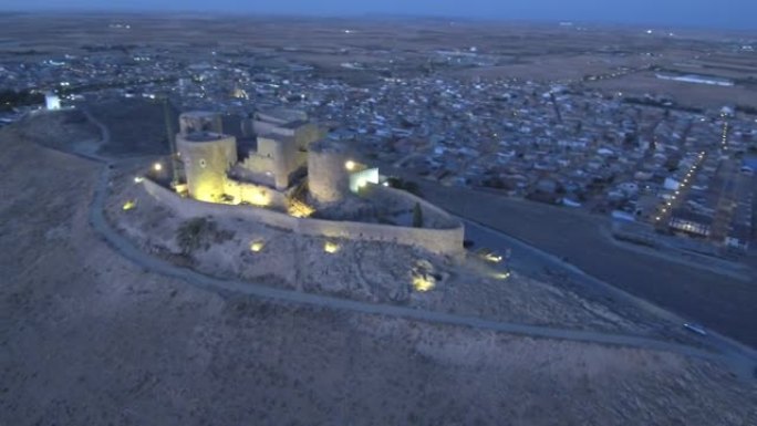 高角度视图山上的一座老堡垒和一个城镇在背景中打开灯在高清