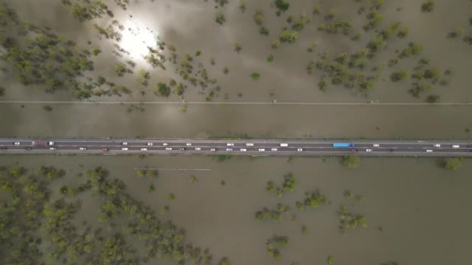 在经过洪水泛滥地区的道路上行驶的交通车的头顶镜头