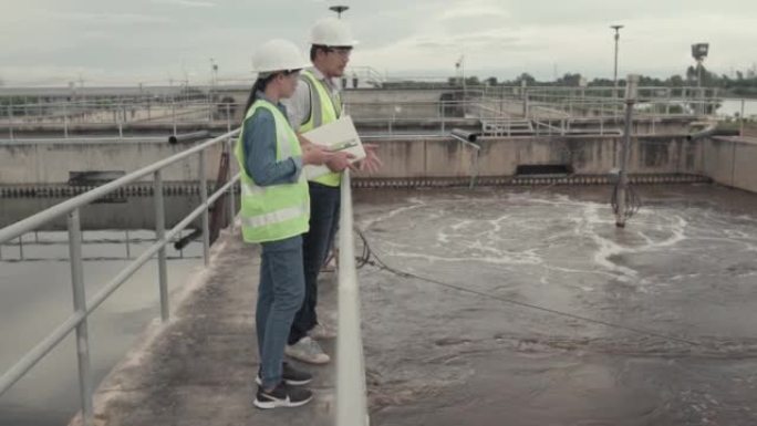两名环境工程师在废水处理厂工作，水管理概念。