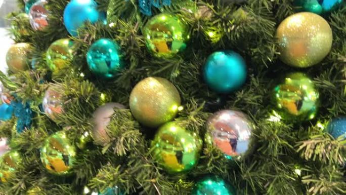 圣诞树上装饰着黄色和绿色的蓝色玩具球和灯YVR温哥华机场金黄色的蓝色球在新年树上，它们闪烁着不同的颜