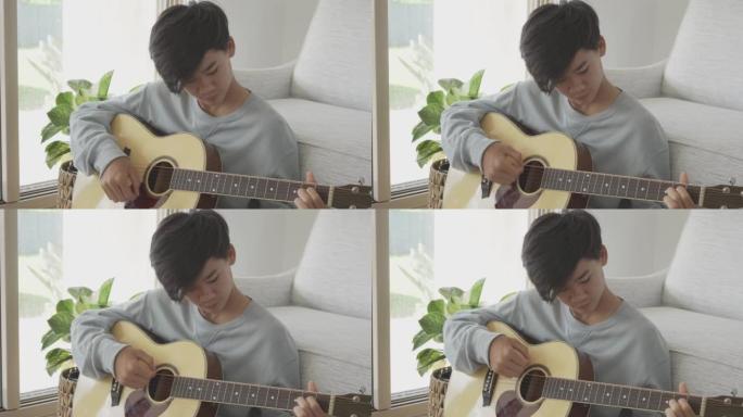混合亚洲少年男孩在家学习如何弹吉他