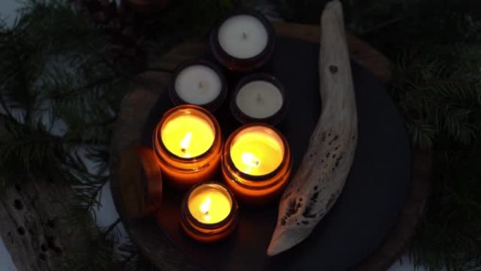 大豆蜡烛在玻璃罐中燃烧。晚上是黑暗的。芳香疗法和放松。在家舒适。棕色罐子里的蜡烛。