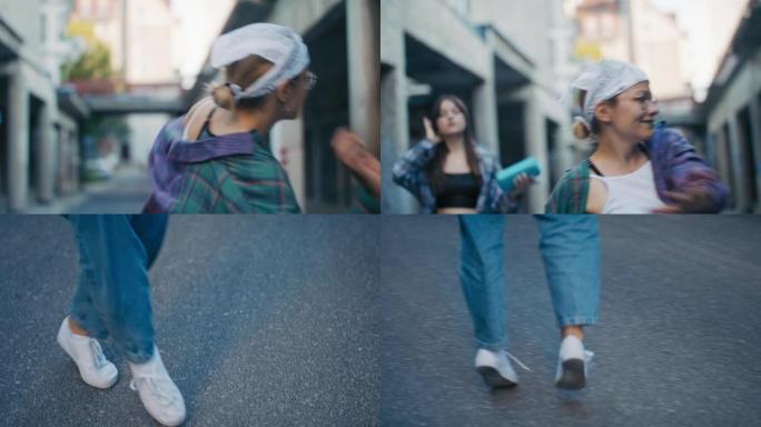 街舞概念。年轻的十几岁的女孩穿着宽松的衣服在城市跳舞，手里拿着扬声器练习舞蹈