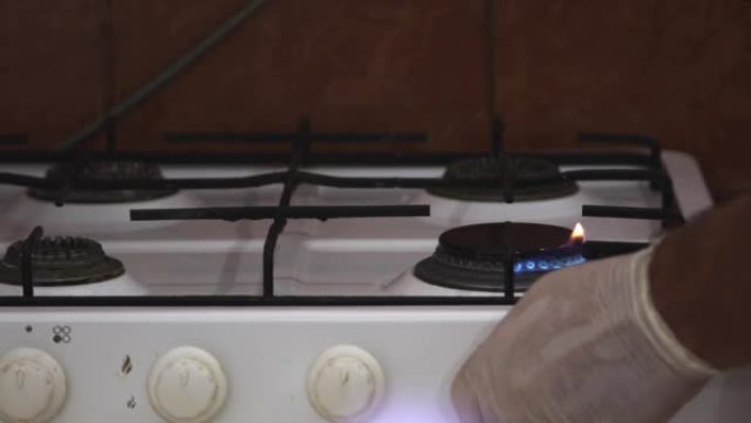 厨师在厨房里烧掉陈旧生锈的蓝色火焰燃气灶