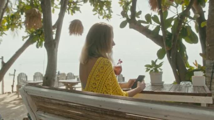 一位白癜风色素沉着的年轻漂亮女子坐在海边，在电话里聊天