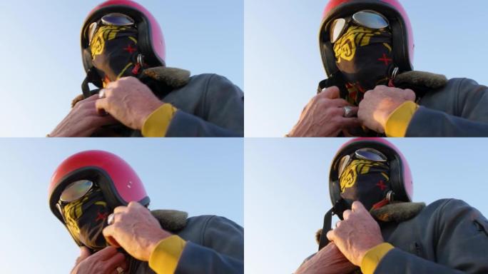 一名男子在离开西班牙Bardenas reles的摩托车之前戴上头盔和围巾