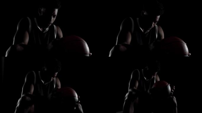 篮球运动员坐在长凳上深呼吸。黑人背景下的非裔美国体育人。