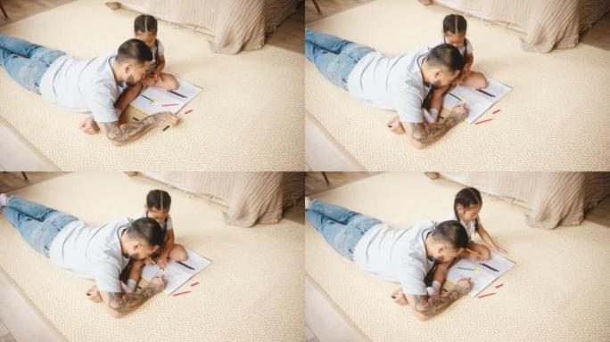 躺在地板上的父亲和女儿一起画画