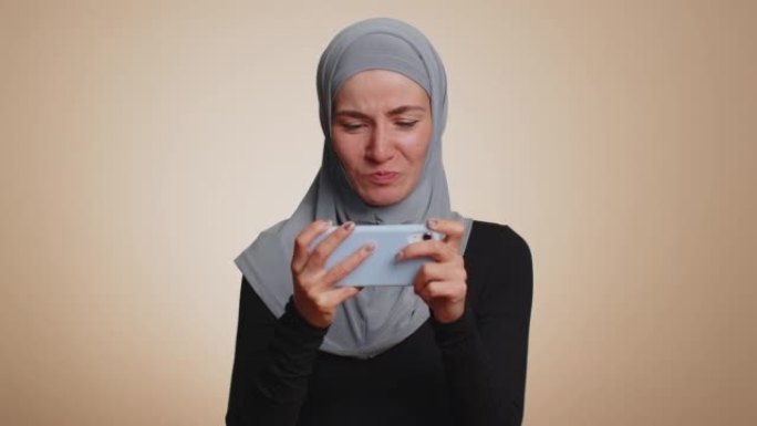 担心搞笑上瘾的穆斯林女孩热情地在手机上玩驾驶赛车视频游戏