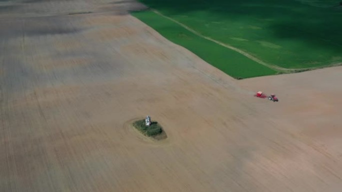 拖拉机在空中小教堂附近的秋季田间播种作物