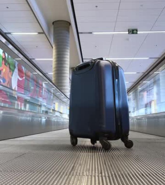 前往不同国家的文字旅行的地方蓝色迷你行李箱在乘客传送带上的轮子上，往前走，在卡尔加里大型机场他独自一