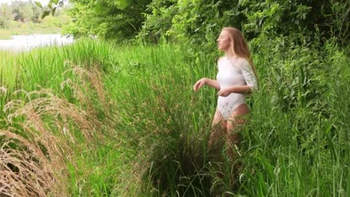 白人少女站在河边的绿草丛中