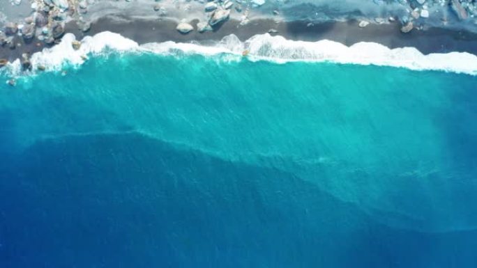 海洋蓝浪在海滩上断裂的空中俯视图。