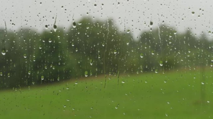 玻璃上的雨滴。夏天的雨滴从窗户流下。窗外下雨。淋浴天气不好。平静放松的冥想平静的背景。阴雨天气秋天抑