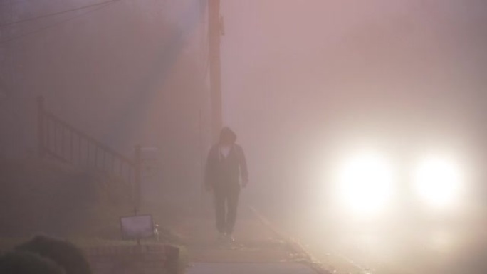神秘男子在雾蒙蒙的早晨走在街上