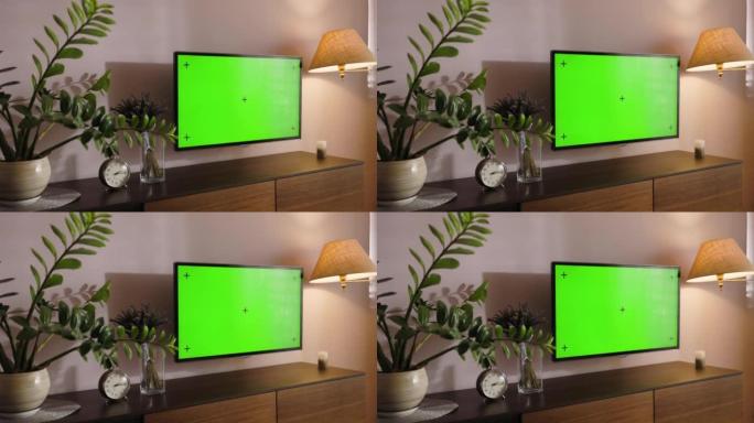 时尚的公寓内部配有带绿屏模拟显示器的电视机，挂在现代马桶下。显示器上的色度键占位符在家中的特写视图。