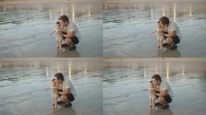 幸福的家庭亚洲爸爸爸爸手抱小女儿婴儿孩子教走路有助于踩浪夏天在海洋海滩上一起玩水，孩子蹒跚学步