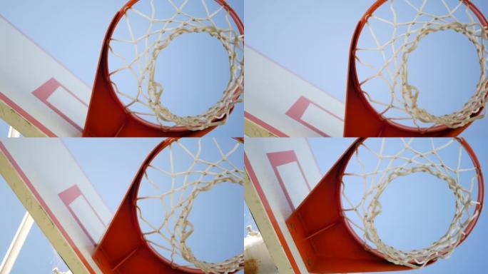 室外篮球场，橙色篮筐，篮球网和篮板。
