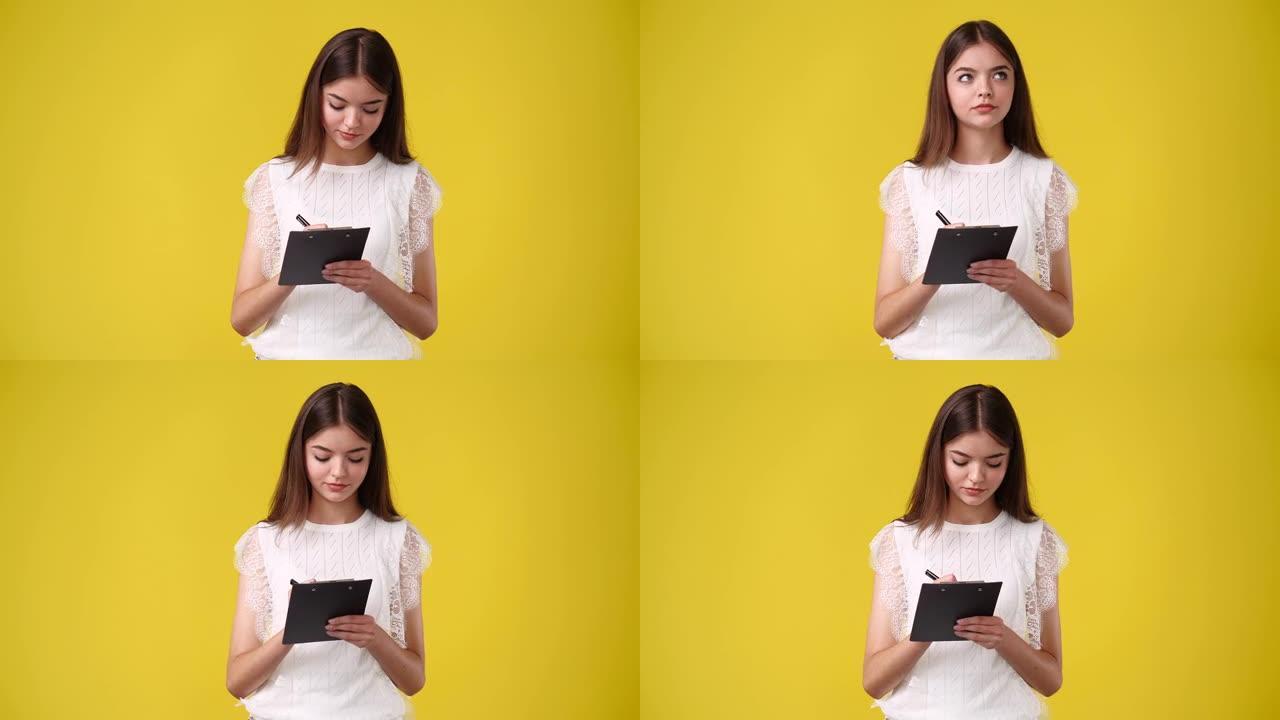 4k视频，女人用黄色背景上的笔记下一些笔记。