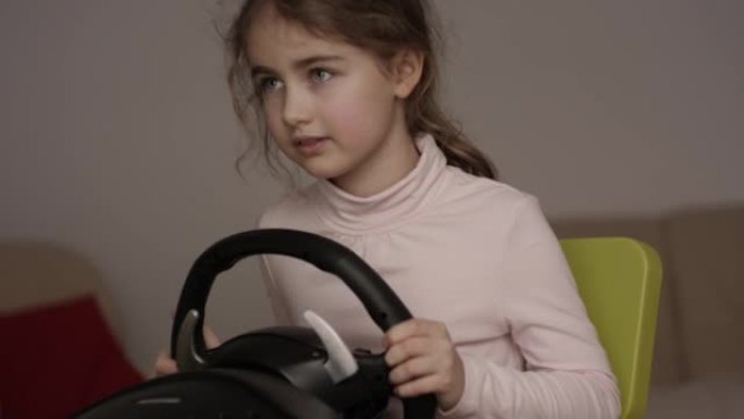 女孩玩赛车视频游戏在游戏机。小孩带着方向盘戴着耳机玩电脑游戏。玩家用耳机握着方向盘玩电子游戏。