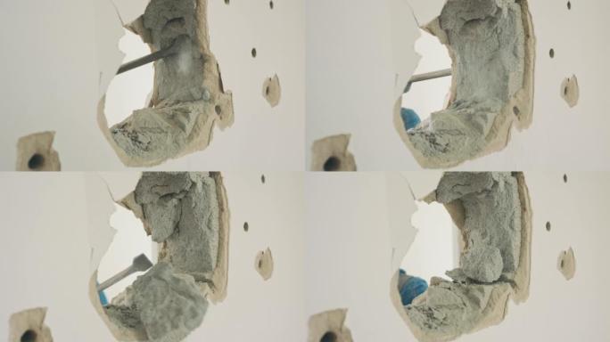墙壁上的孔的特写镜头，该孔被手持式手提钻拆除