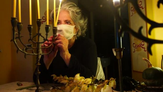 一名西班牙裔妇女在犹太庆祝活动Hannukah上移动烛台的镜头