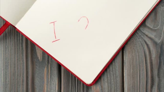 红色日记本，白纸移至中心，标志着我爱你，出现在带有红色阴影心的页面上。爱情信息