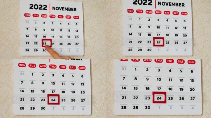 一个美丽的2022年11月挂历页面的特写和一只男性的手将红色光标移到感恩节日期