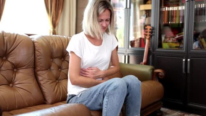 悲伤的女人坐在家里的沙发上，流产或流产后受苦