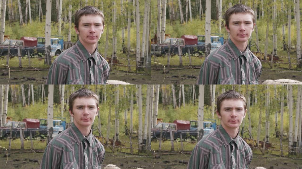 美国科罗拉多州一个小镇家族牧场上，一名英俊的男性高加索牧场主少年和他的羊站在一起，看着相机的视频肖像