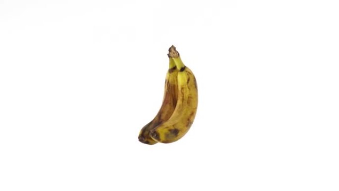 成熟的黄色香蕉旋转挂在白色背景上，孤立。模拟，放置文本，复制空间。工作室拍摄。