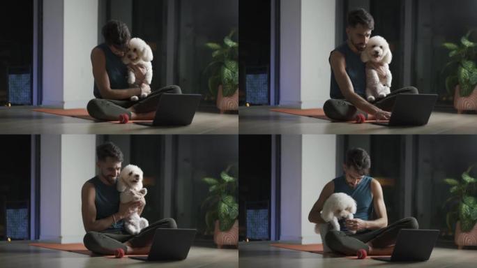年轻的拉丁男子在锻炼时休息一下，和他的狗一起玩