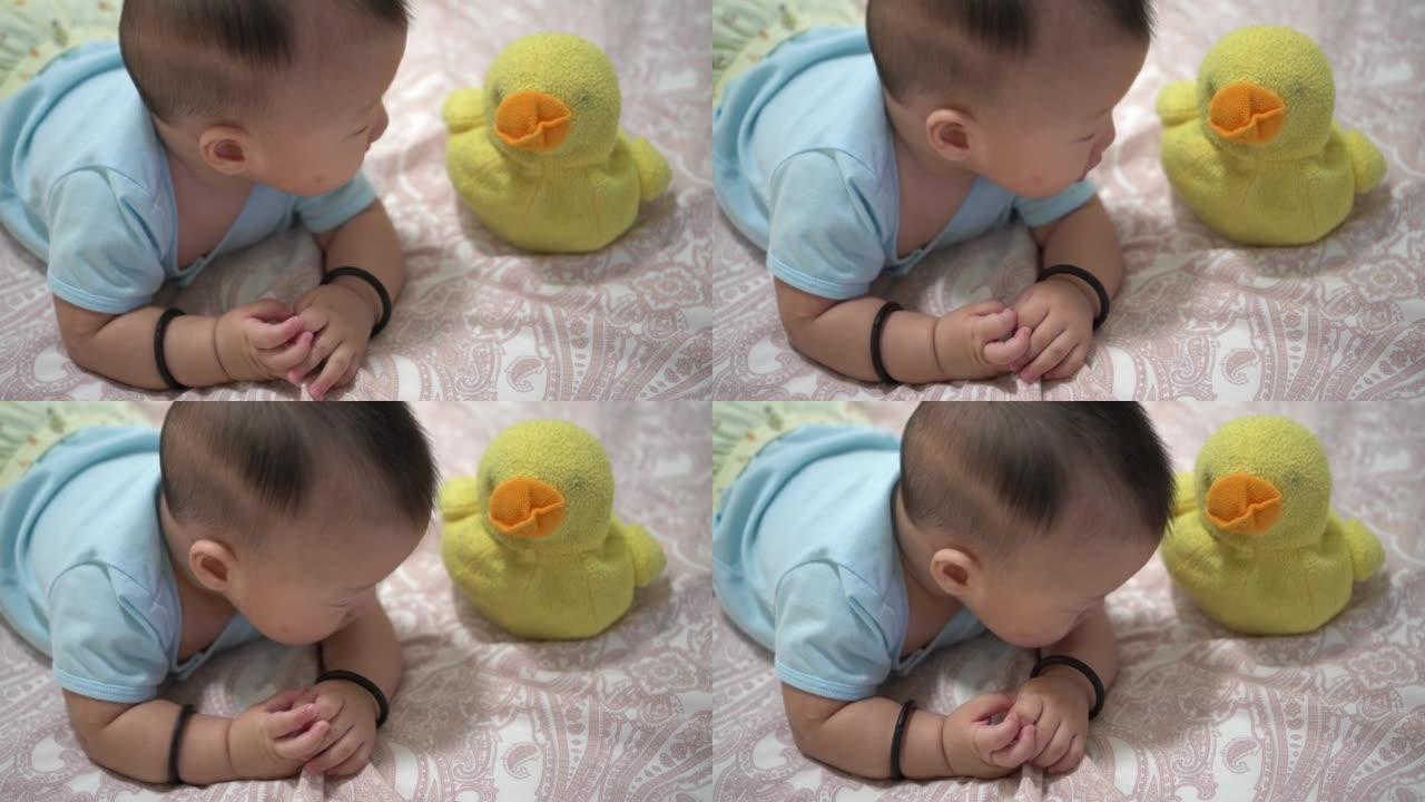 婴儿与旧黄鸭毛绒玩具