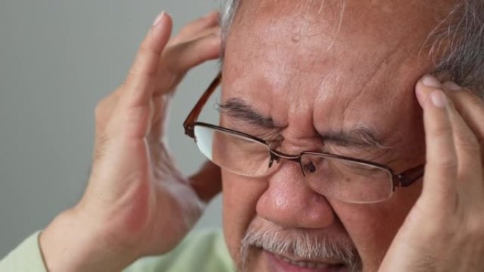 亚洲老年老人在家里的客厅感到头痛和偏头痛。强调成熟男性伤害精神卫生护理和保险理念。