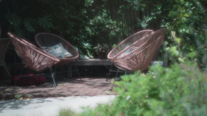 花园甲板上的现代棕色户外椅子被树木环绕