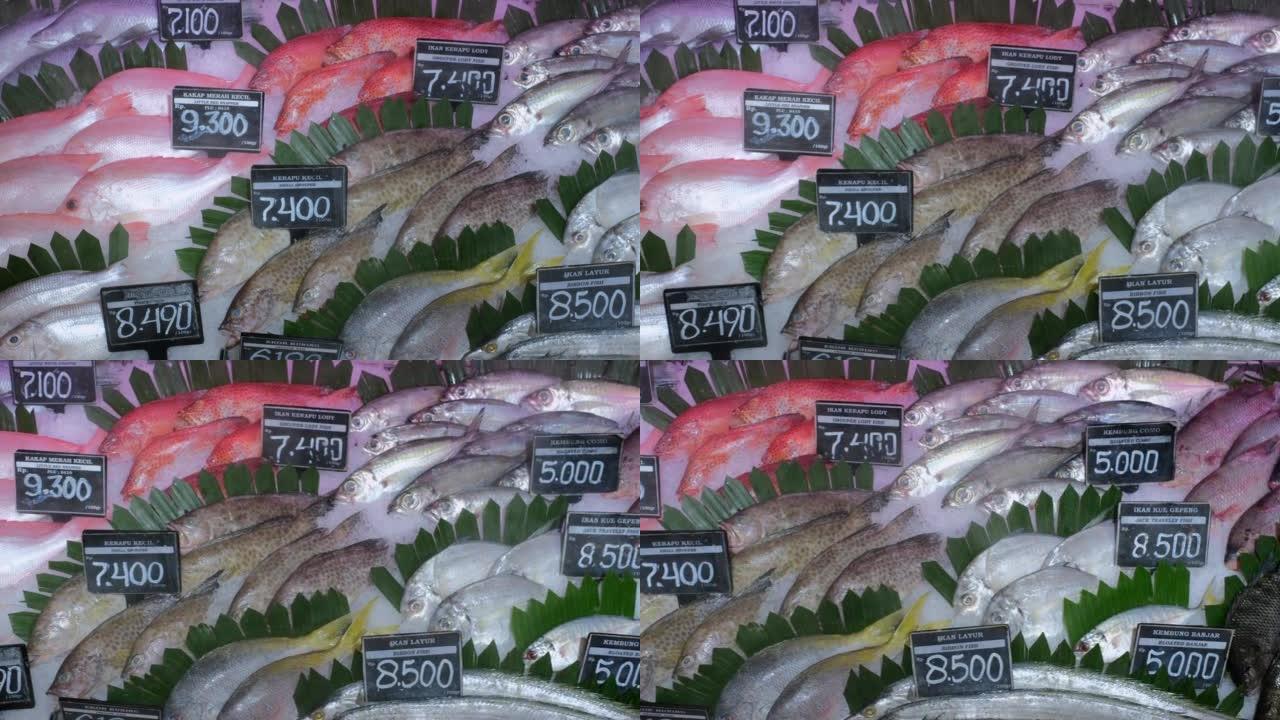 海洋附近市场上的摊位上有很多新鲜的海鲜鱼，有冰和绿叶，价格标签。从当地水库在超市出售鱼，以养鱼