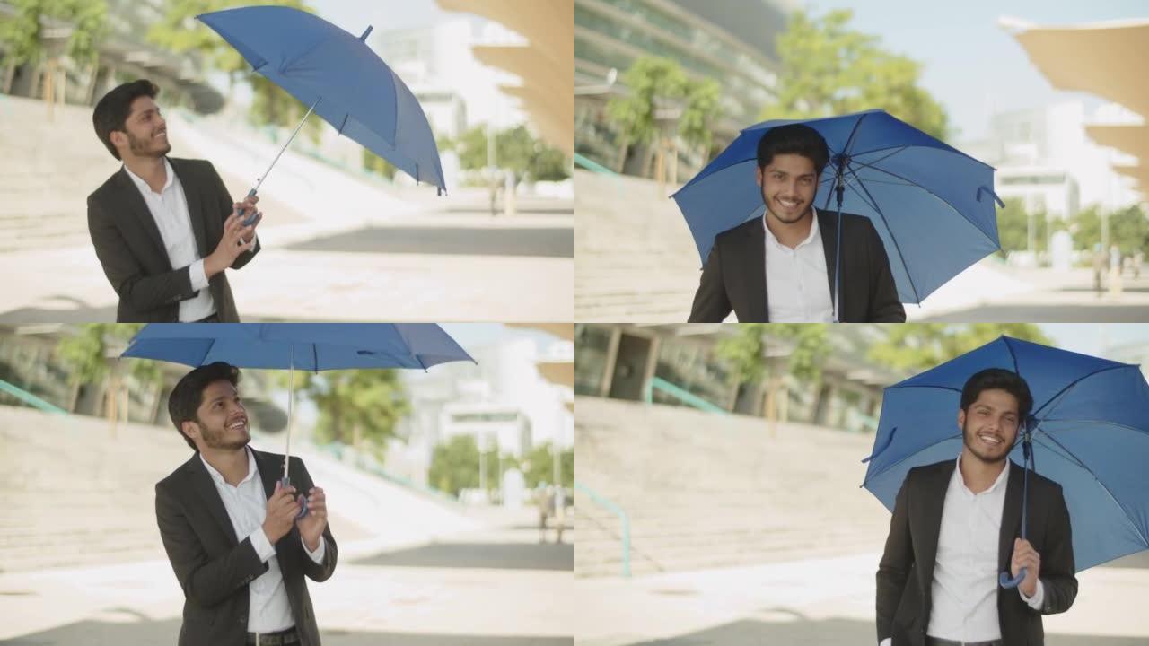 年轻的穆斯林男子打开蓝伞，躲避阳光。