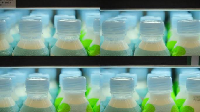 超市货架上有很多小塑料瓶饮料。展出的乳制品。每天使用塑料会导致难以分解的垃圾的形成，污染地球。