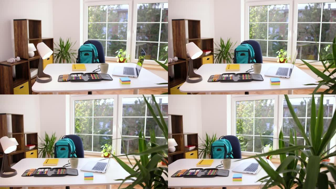 现代化的房间，桌子上有学习用品和笔记本电脑