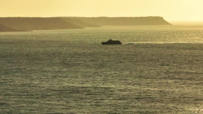 日落时海岸线附近船只的鸟瞰图