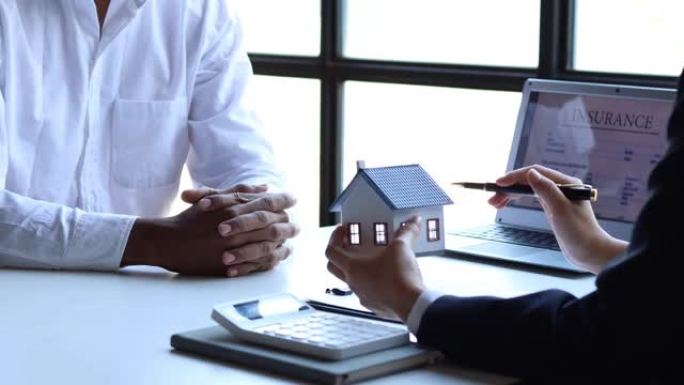 房地产经纪人解释项目中的房屋模型，以向客户详细说明，解释并介绍有关房屋和购买贷款的信息。房地产交易概
