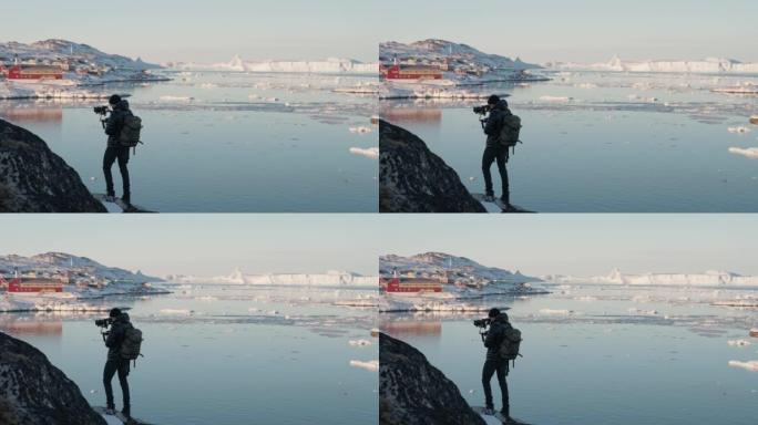 男子在城镇冰冷的海岸线上用相机拍摄