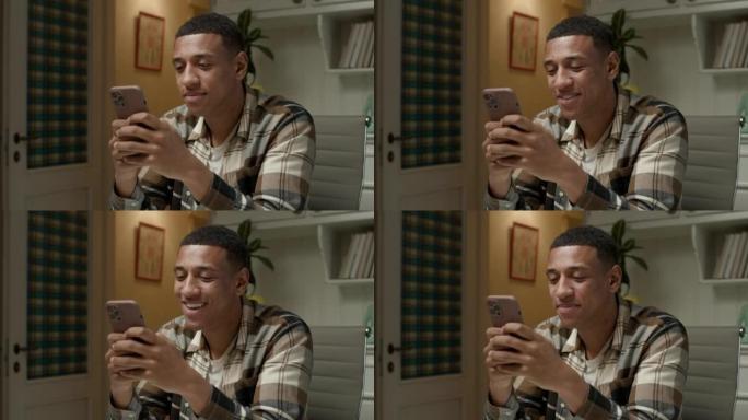 男人用手机打字。非裔美国人使用智能手机在线聊天。微笑的年轻成人牢房。