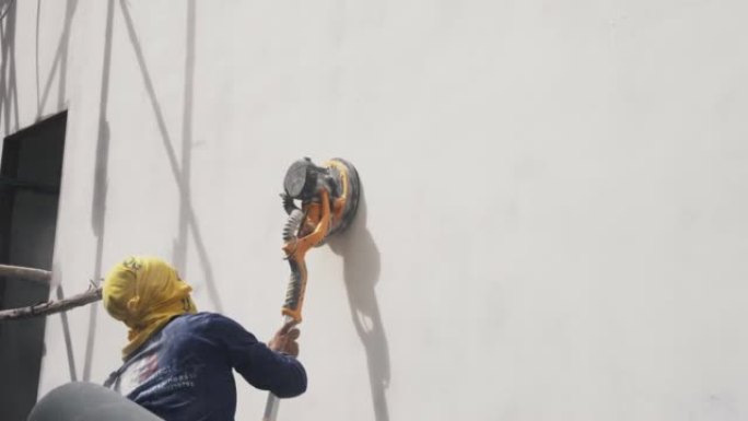 房屋油漆工与砂光机一起工作