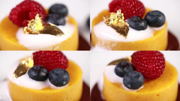 用蓝莓，覆盆子和金片装饰的新鲜美味芒果慕斯的特写镜头